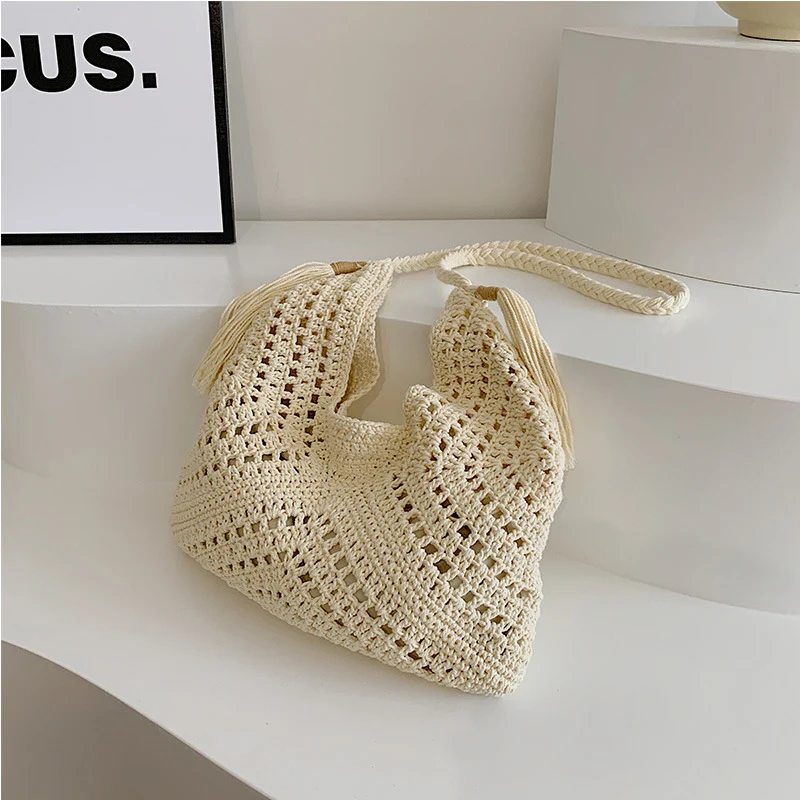 A single-shoulder hand-held women's bag made of straw with a drawstring inner pocket